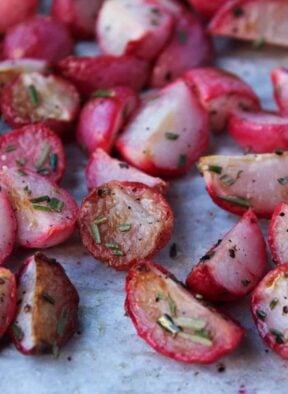 Close up on garlic roasted radishes tossed with fresh rosemary.