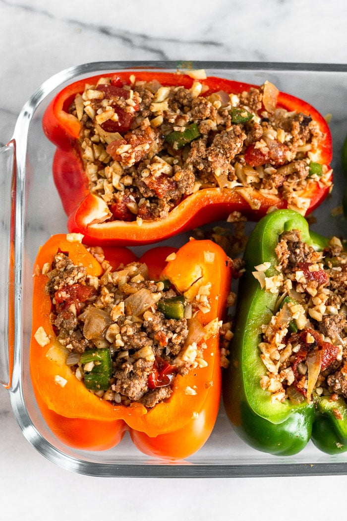 Glass baking dish filled with beef stuffed peppers before they are baked.