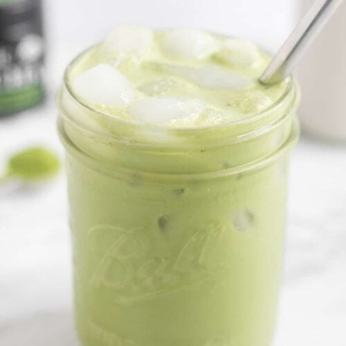 Large glass filled with a paleo iced matcha latte with a metal straw in it