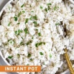 Overhead shot of Instant Pot coconut rice in a bowl topped with fresh cilantro. A spoon is also in the bowl.
