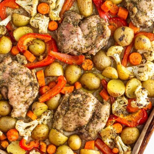 Sheet pan za'atar chicken with roasted potatoes, carrots, cauliflower, and red bell peppers.