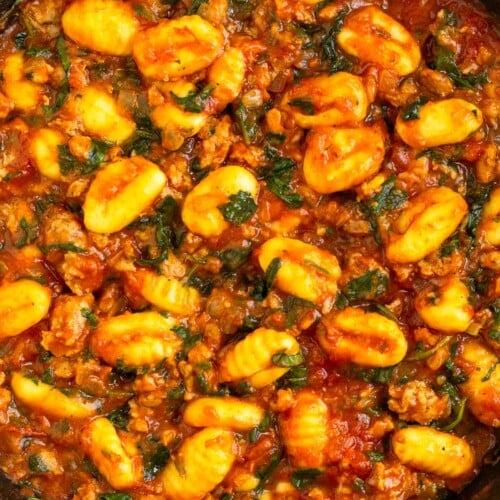 Sausage gnocchi skillet with spinach mixed with pasta sauce in a large pan.