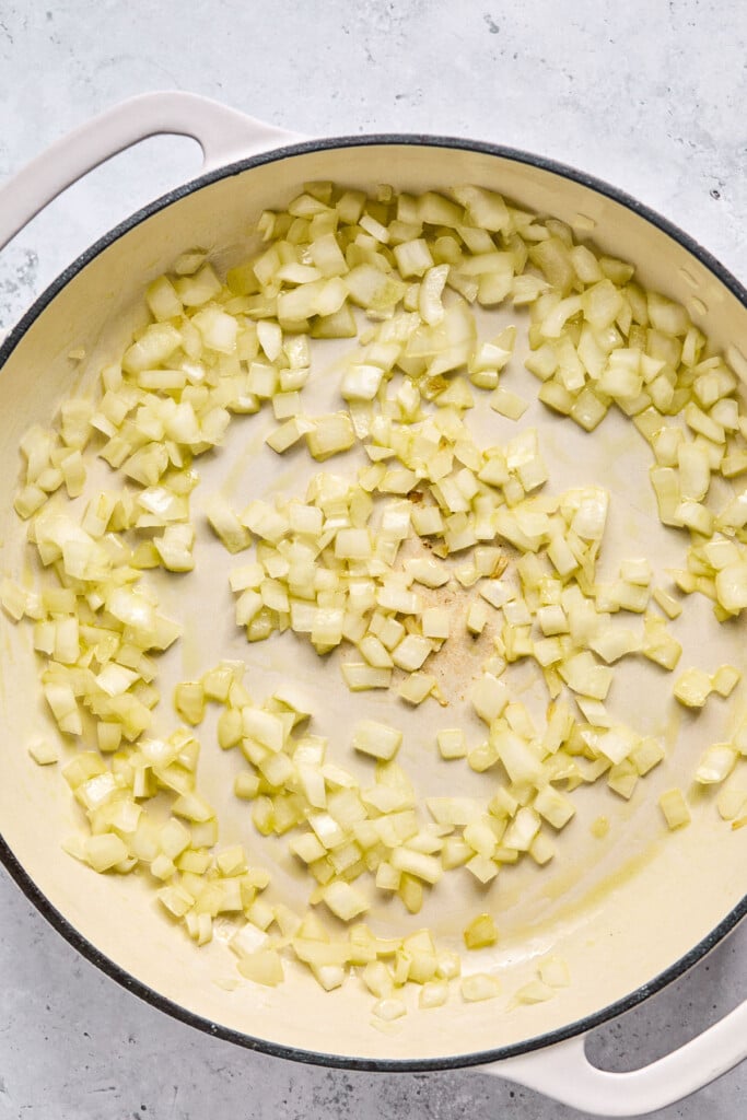 Large enameled pan filled with saut&eacute;ed onions.