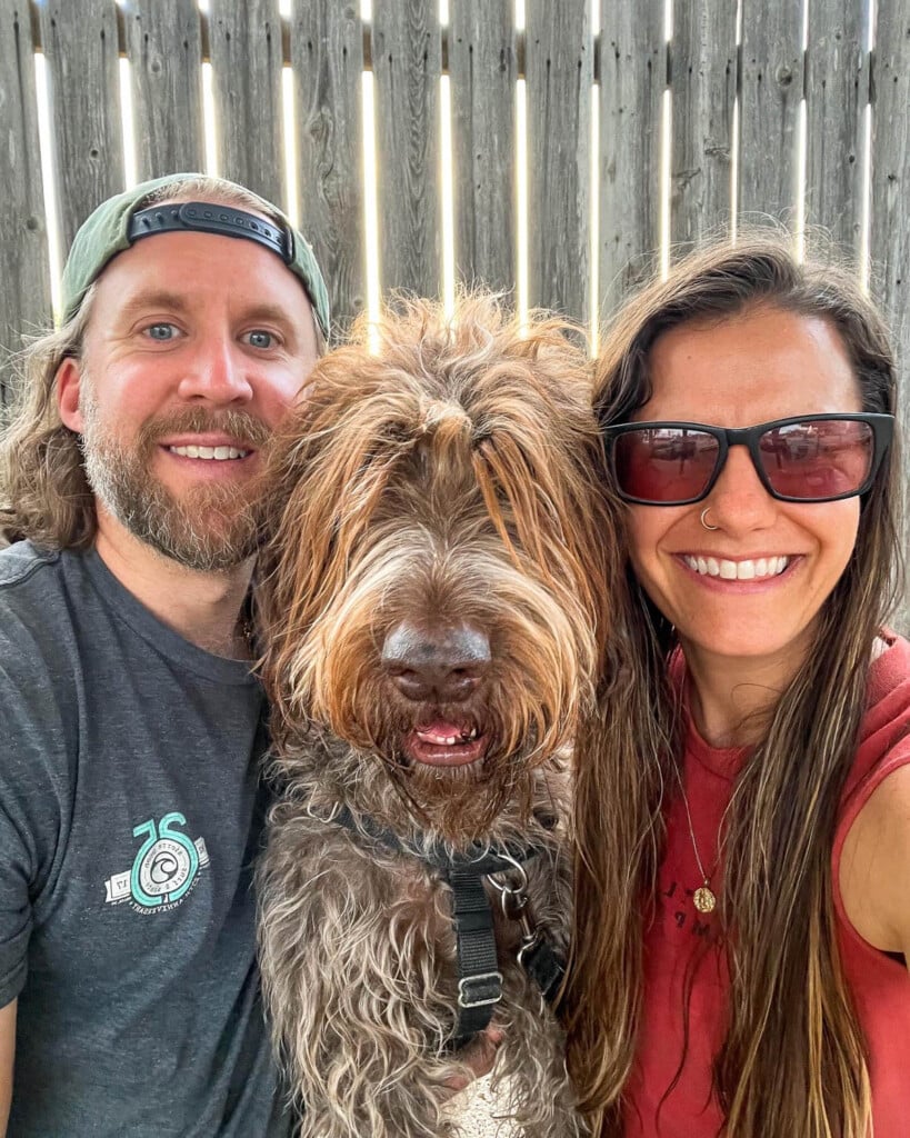 A selfie of a husband and wife with their dog.