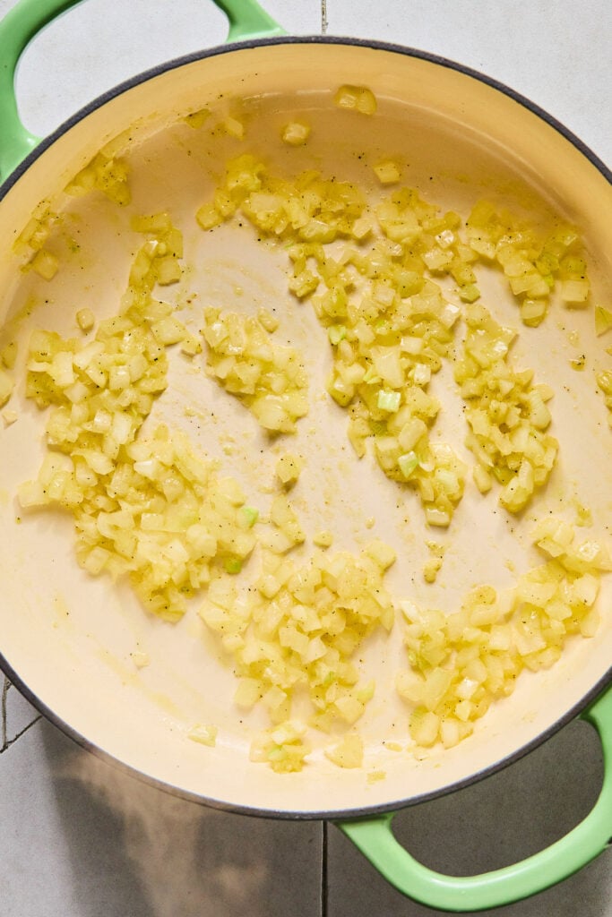 Large enameled pan filled with saut&eacute;ed onions and garlic.