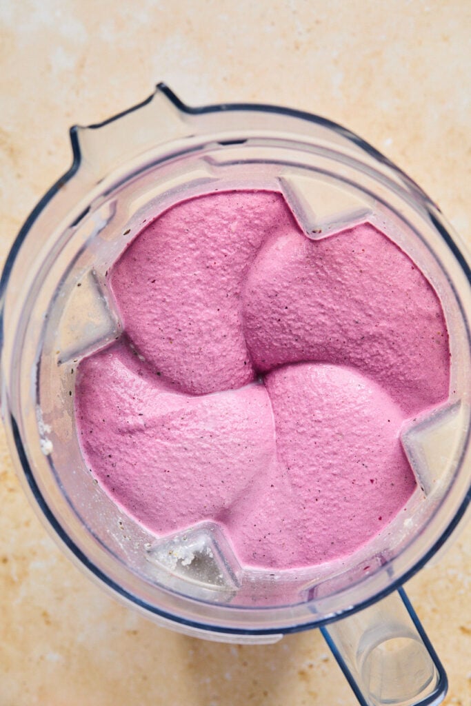 Overhead shot of a creamy pink smoothie in a blender.