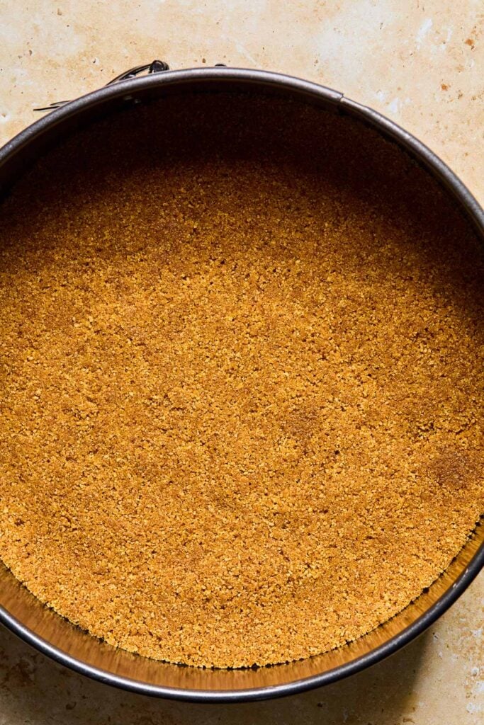 Graham cracker crust in a cake pan.