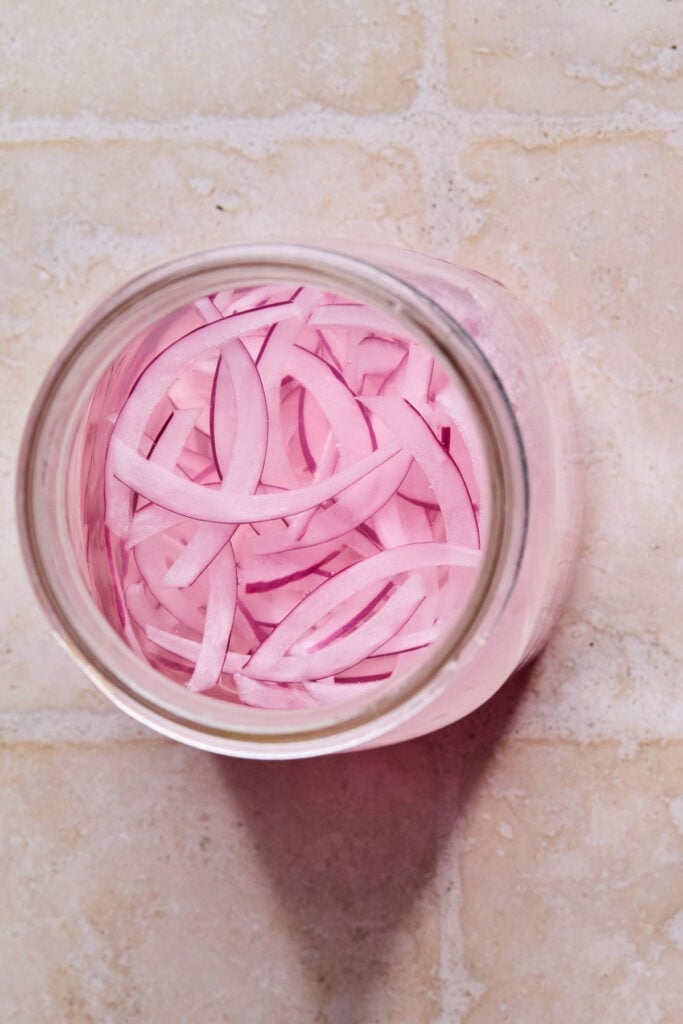 An overhead shot of a jar of pickled onions.