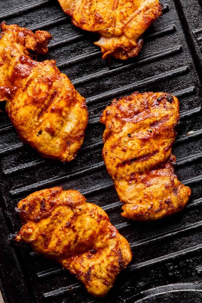 Close-up of a grilled chicken thigh on the grill.