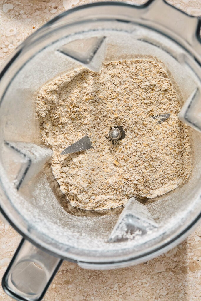Overhead shot of a blender filled with oat flour that has just been blended.