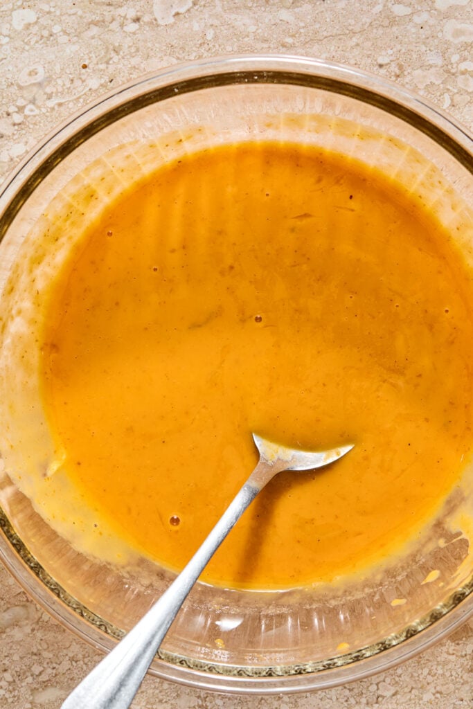Wet batter in a bowl with a spoon in it.